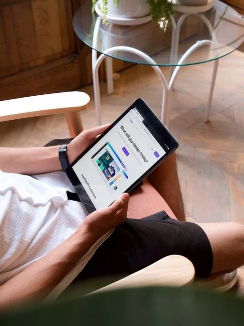 Close-up of a notebook with wireframe sketches and a smartphone on a wooden desk.